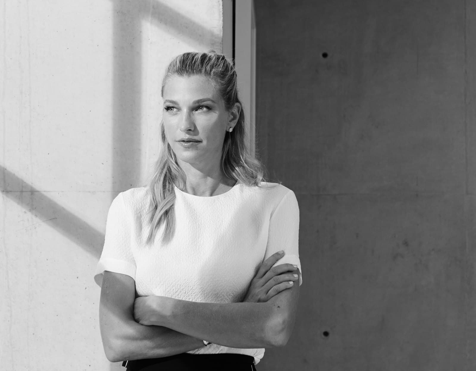 Nicole Junkerman standing calmly against a soft, light-filled wall