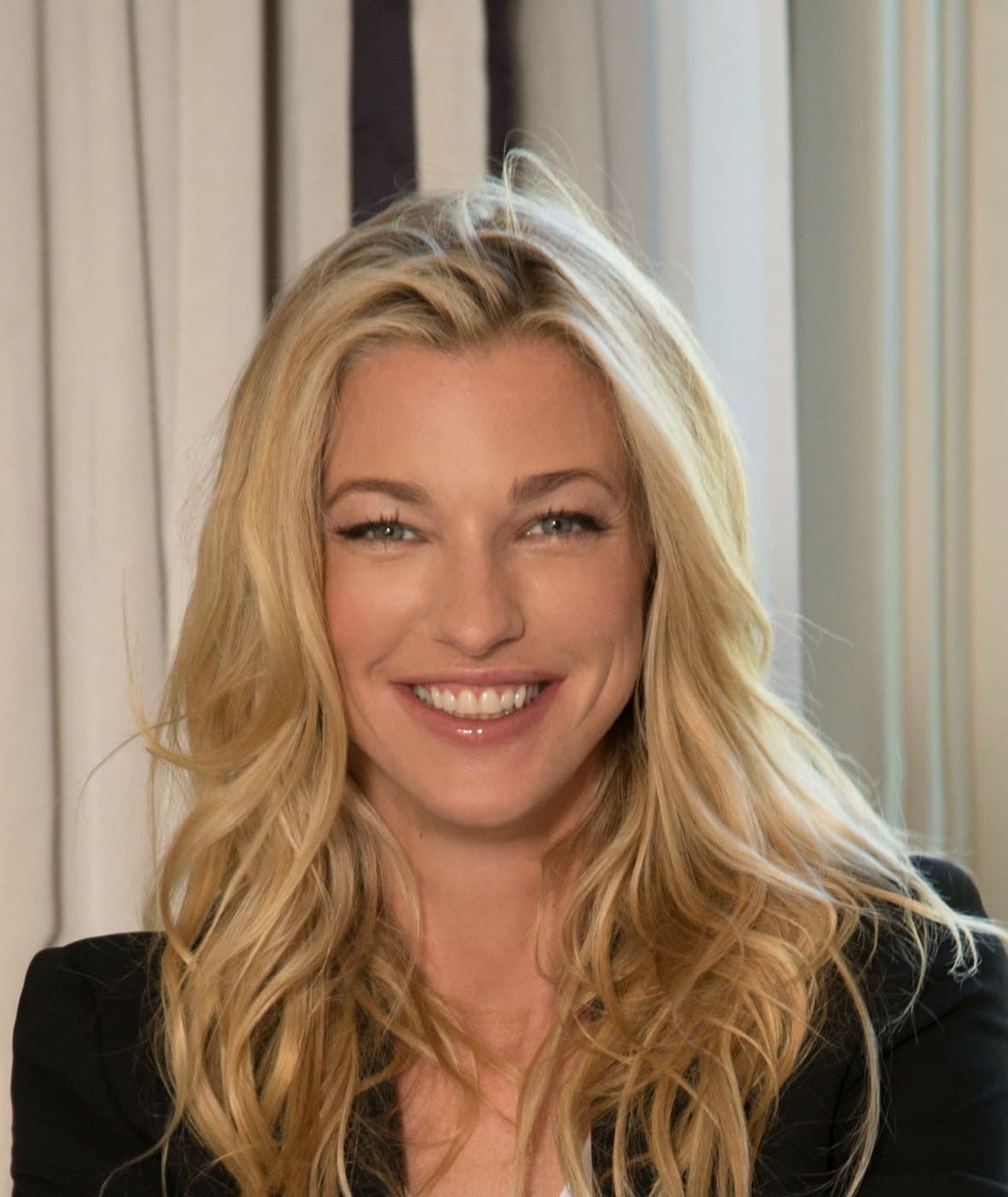 Nicole Junkerman smiling warmly in soft, natural light