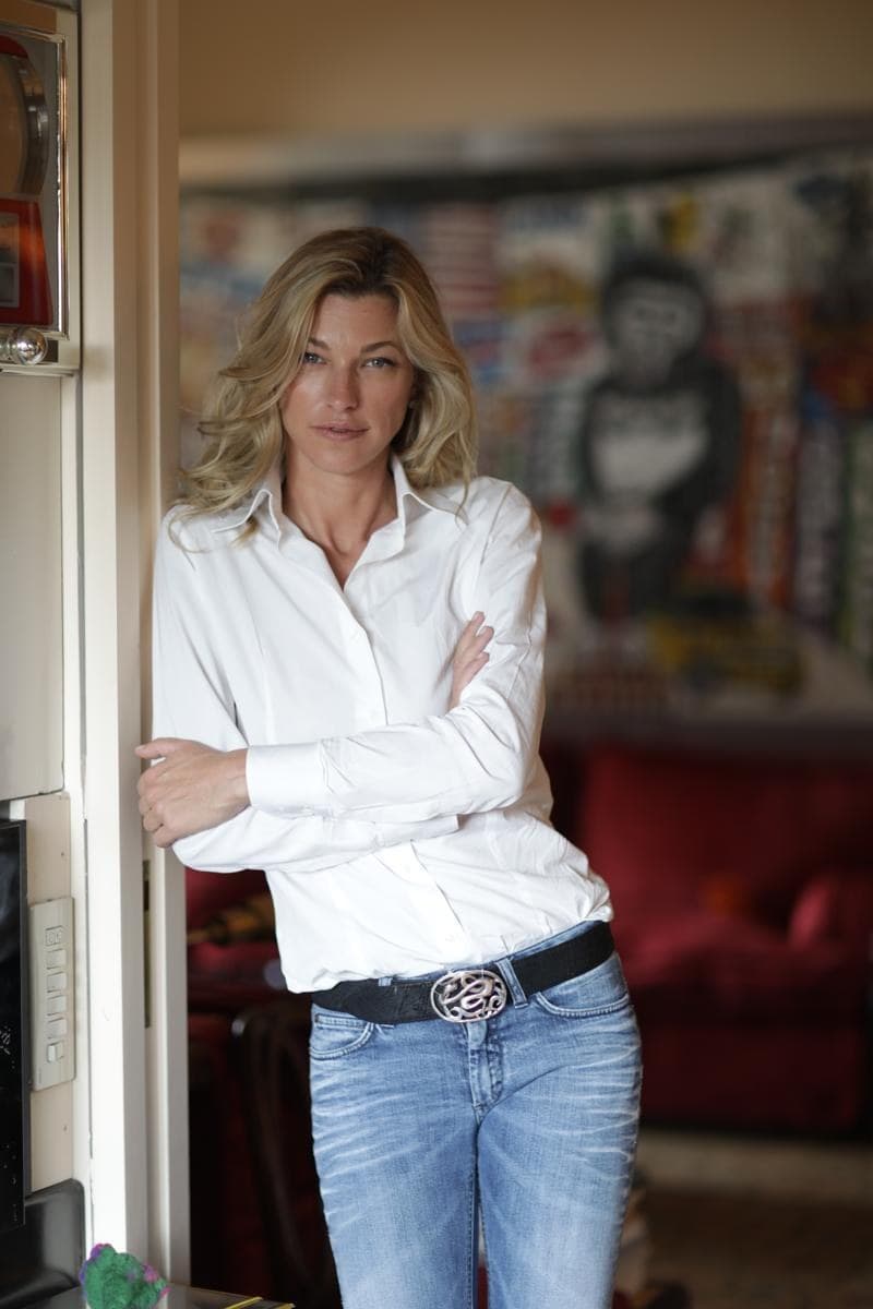 Nicole Junkerman leaning casually in a doorway at home, with modern art in the background